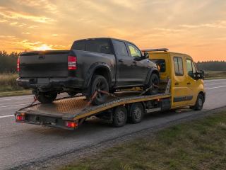 Pickup wciągnięty na platformę o zachodzie słońca – wyciąganie z rowu w Zamościu